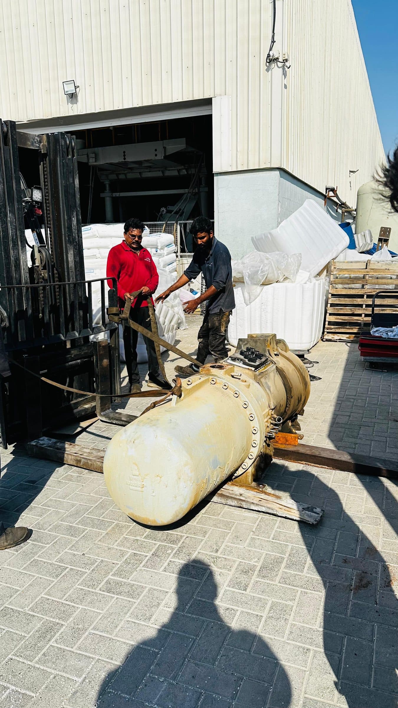 Technicians with a screw compressor on the workshop yard
