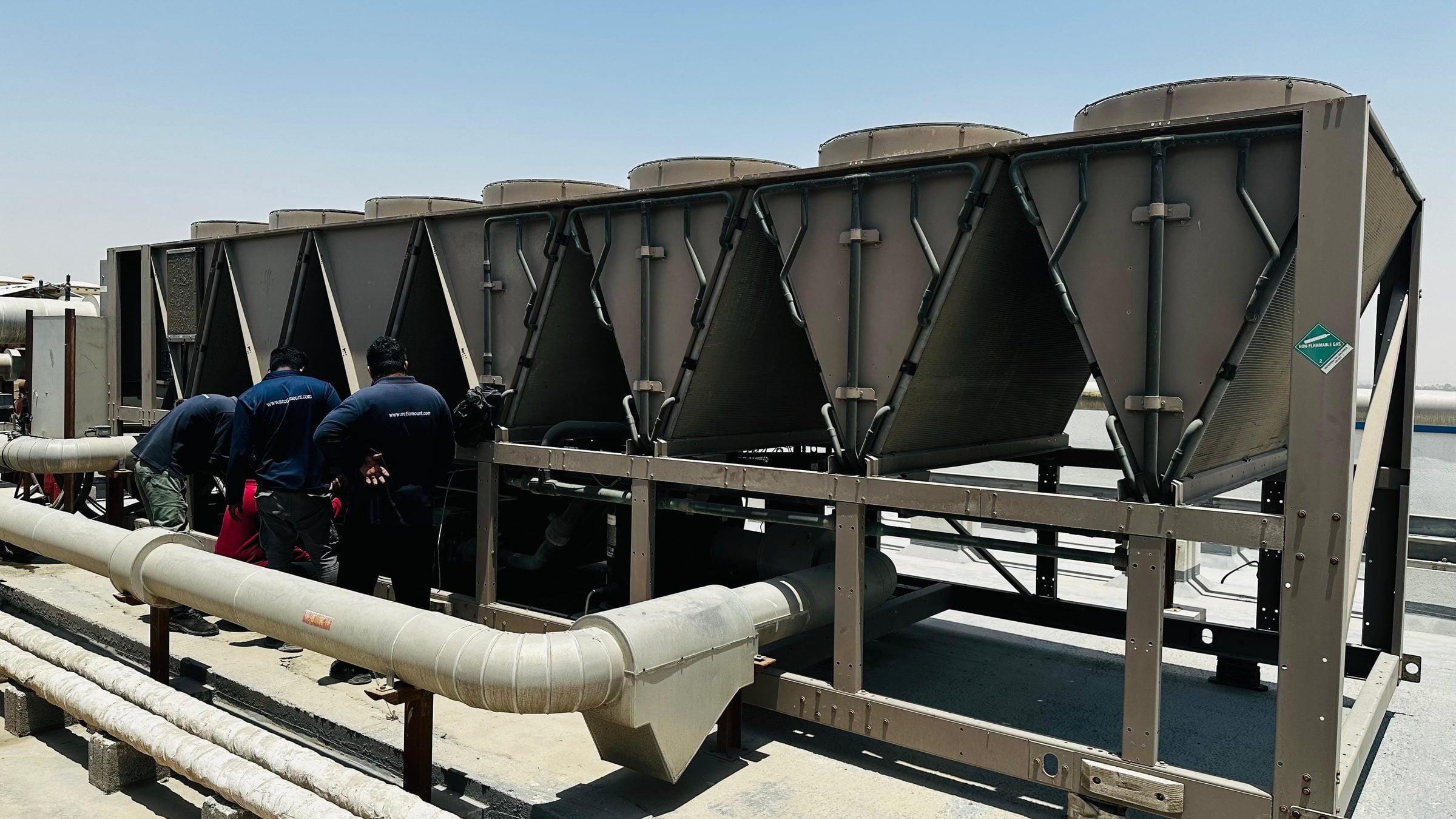 Arctic Mount team working on a rooftop air-cooled chiller plant