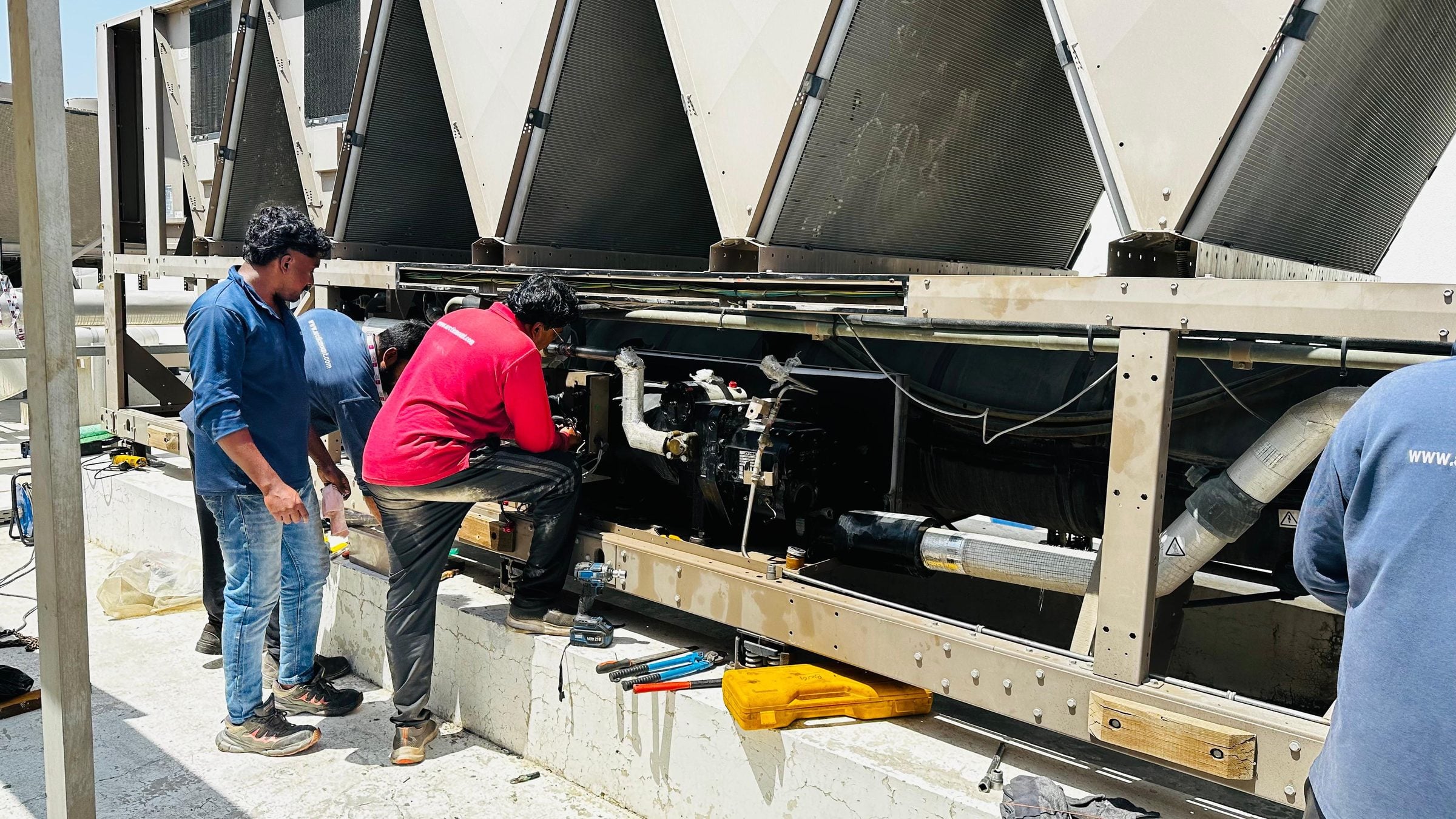 Arctic Mount technicians carrying out compressor work on a rooftop air-cooled chiller